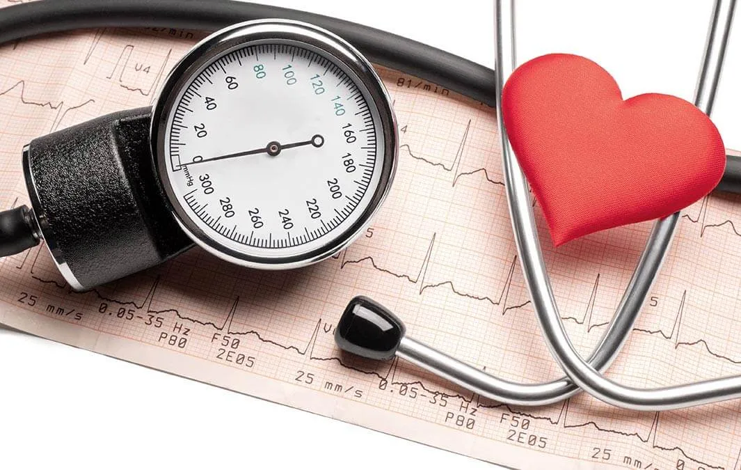 Merilnik krvnega tlaka in stetoskop na izpisu EKG